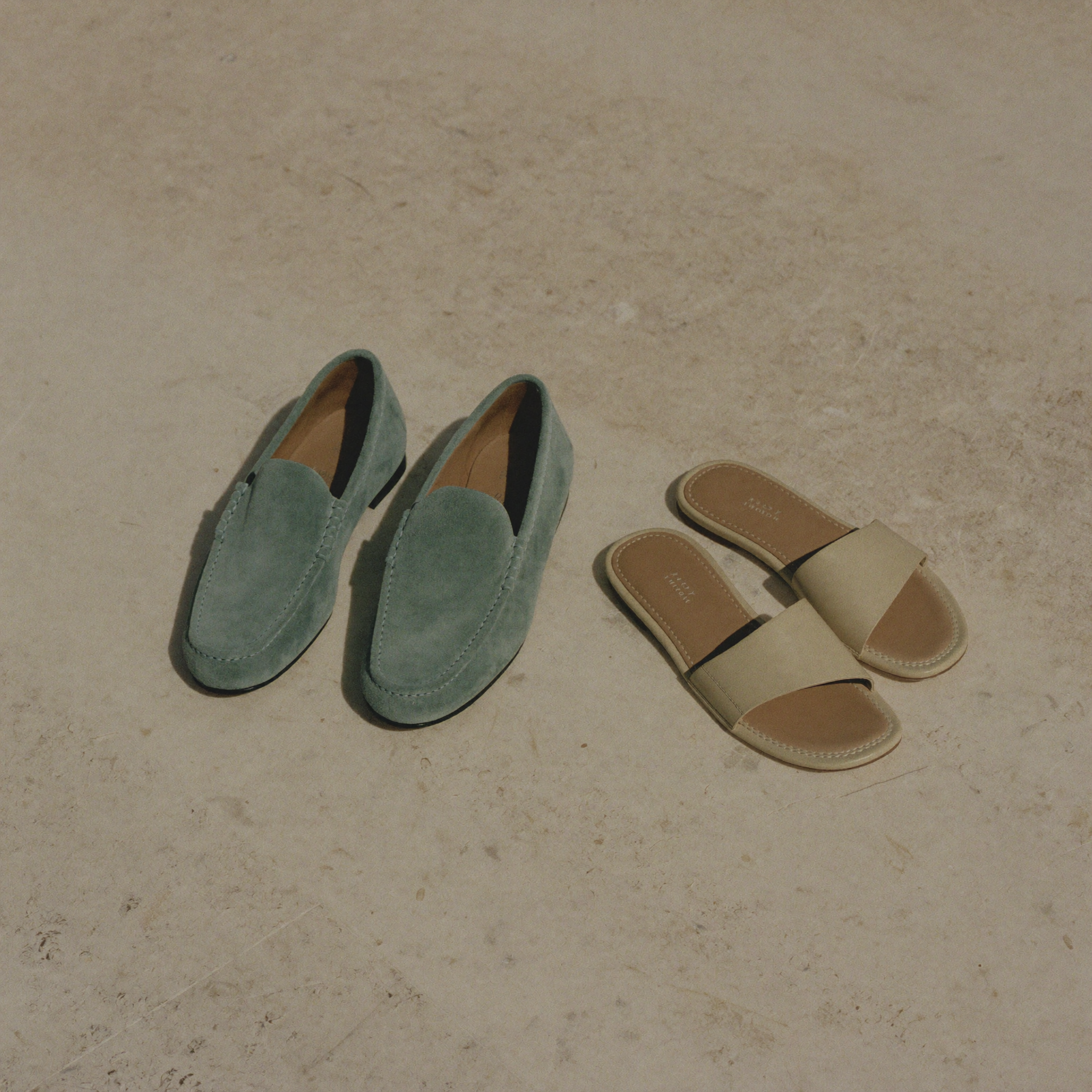 Suede loafers and bone leather slides on warm limestone