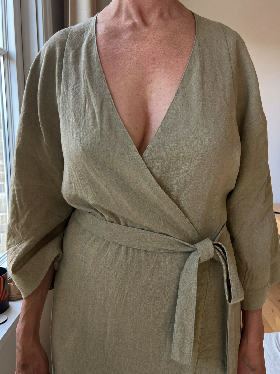 The Verona Wrap Dress in Sage, near a window